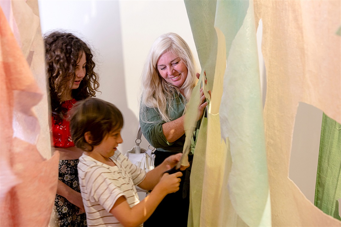 Visitors with Lara Merrett Artwork - Photograph by Bernie Fischer